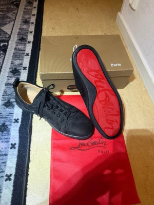 Svarta sneakers med röd sula - Säljer mina Loubs som jag använt 3-5 gånger har ingen nytta till de längre så de bara höra av sig om ni är intresserade😄 Storlek 45 men passar på 44