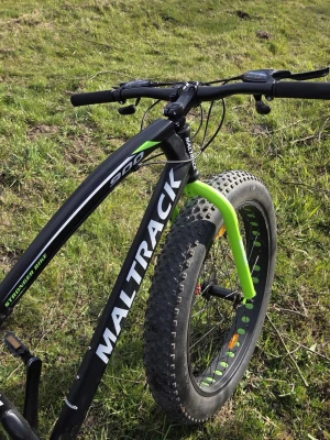 MALTRACK Fatbike svart/grön - Säljer en MALTRACK fatbike med breda däck, svart ram med gröna detaljer och vit logga. Cykeln har Shimano-växlar och sportig design, perfekt för terräng och äventyr. Sadel och handtag har gröna inslag som matchar framgaffeln.