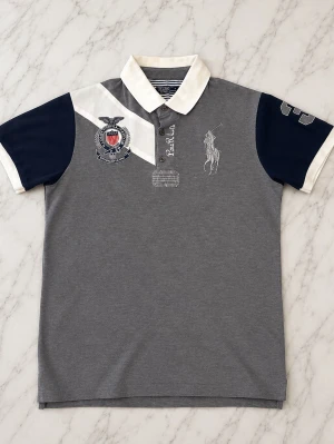 Ralph Lauren Piké  - Säljer en snygg grå polo piké i storlek M. Skicket är mycket bra och det förekommer inga defekter. 