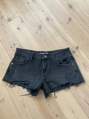 Svarta jeansshorts med slitningar - Säljer dessa jeansshorts från zara. De är omsydda till lågmidjade och har slitningar. Midjemått 37 cm tvärs över midjan. Kontakta mig gärna privat vid frågor eller liknande💗💗