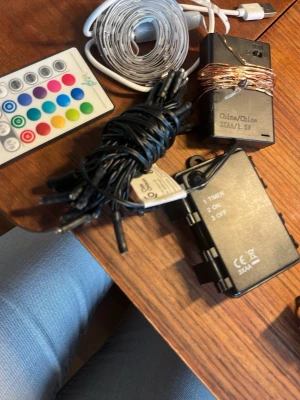 Fjärrstyrda LED-ljusslingor och kontroll - Säljer ett paket med flera LED-ljusslingor, fjärrkontroll och batteridosor. Slingorna är i olika färger och material, med både koppartråd och plast. Perfekt för dekoration och mysbelysning, styrs enkelt med medföljande fjärrkontroll.