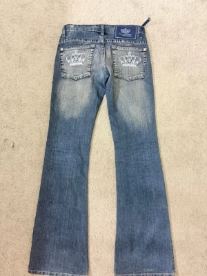 Blå bootcut jeans Victoria Beckham - Snygga blå bootcut jeans från Victoria Beckham för Rock & Republic. Jeansen har slitningar, två bakfickor med kronor. Ända problemet är att knappen är av så jag knöt helt enkelt shortsen med ett snörre.  MEN KNAPP FINNS KVAR. En av delarna längst upp på jeansen är sönder men är lätt att sy. PRIS KAN DISKUTERAS 