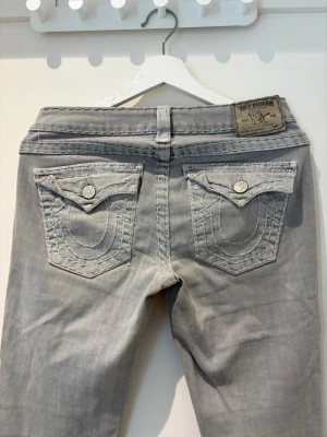 Grå True Religion jeans med fickdetaljer - Midja 37.5 cm innerbenslängd 76 cm. Se sista bilder för små defekter. 