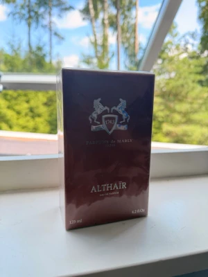 Parfums de Marly Althaïr EdP 125ml - Exklusiv parfym från Parfums de Marly, Althaïr Eau de Parfum i 125 ml. Flaskan kommer i en elegant mörkbrun förpackning med silverdetaljer och klassisk logga. En lyxig doftupplevelse för dig som gillar unika och sofistikerade parfymer.