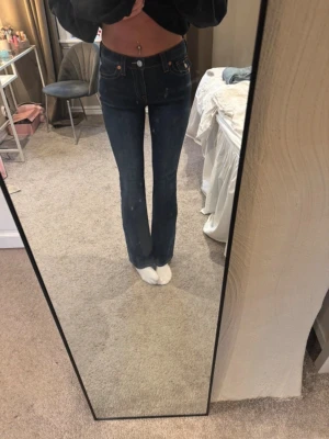 True religion jeans - Snygga mörkblå jeans i modellen mid rise bootcut från Becca. Jeansen har klassiska orange sömmar, fem fickor och en smickrande passform som är smal över låren och utsvängd nedtill. Perfekta för dig som gillar en retroinspirerad look.