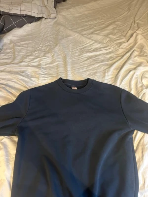 Mörkblå sweatshirt från Colmar - En stilren mörkblå sweatshirt från Colmar Originals. Tröjan har rund halsringning och ribbade muddar vid hals, ärmslut och nederkant. Perfekt för en avslappnad och snygg look. Materialet känns mjukt och bekvämt mot huden. Riktig bra kvalité då jag knappt använt den. Nypris:1099 Mitt pris:599. Priset kan diskuteras 