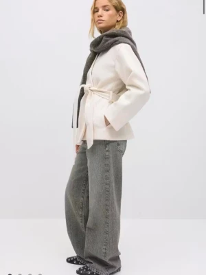 Krämvit kappa med knytskärp - Stilren krämvit kappa i mjukt tyg med avslappnad passform och knytskärp i midjan. Kappan har raka ärmar och ingen synlig knäppning, vilket ger en minimalistisk look. Perfekt för dig som gillar enkel och modern stil. Använd 2 gånger endast! 