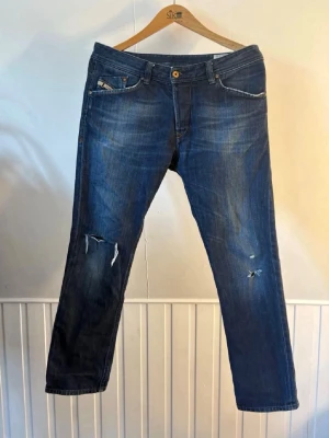 Blå slitna jeans med raka ben - Säljer dessa diesel jeans med slitningar och riktigt snygg färg/fade. Storlek 30L 33W så passar ungefär 172-182 och 75-85kg. 