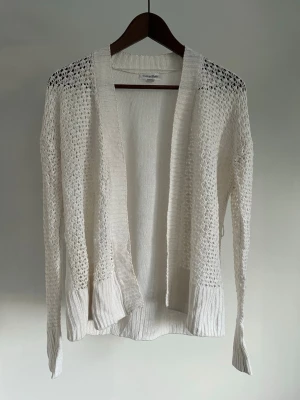 Calvin Klein Vit Linnekofta Open Knit Cardigan Linne/Rayon | Dam M - Calvin Klein Vit Linnekofta Open Knit Cardigan Linne/Rayon | Dam M Storlek: M Färg: Off White Passform: Regular fit  Krage: Öppen front Material: 55 % linne & 45 % rayon (viskos) Skick: Denna linnekoftan är i ett väldigt fint skick utan defekter  Nypris cirka: 1 100 kr