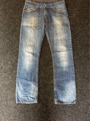 Levis 501 - Säljer ett par riktigt snygga Levis 501 jeans med raka ben och snygga slitningar framtill. Jeansen har klassisk femficksdesign och kontrastsömmar. Perfekta för en avslappnad och trendig look. Säljer för att de är för små på mig. Hör av er vid frågor