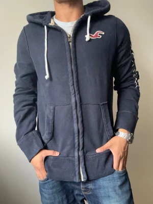 Vintage Hollister Zip Up ’1922’ - Sjukt snygg Hollister Zip Up Hoodie, svår att få tag på | Mycket bra skick | Storlek L | Modell 175cm, 69kg | Hör av vid funderingar! Skickas direkt med instabox!