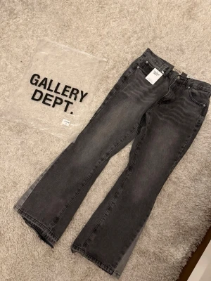 Svarta bootcut jeans från Gallery Dept. S - Säljer ett par svarta bootcut jeans från Gallery Dept. Jeansen har klassisk femficksdesign, raka ben med lätt utsvängning och är tillverkade i kraftig denim. Perfekta för dig som gillar en avslappnad men trendig look.