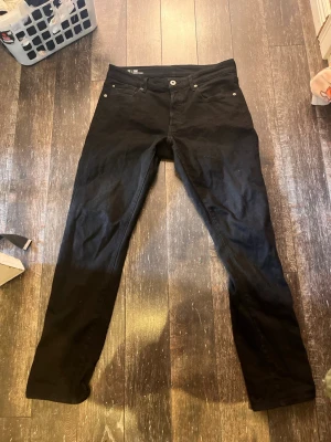 Svarta G-Star RAW 3301 jeans - Säljer ett par svarta G-Star RAW 3301 jeans med straight tapered passform. Klassisk femficksmodell med silverfärgade nitar och knapp. Snygga och stilrena jeans som passar till det mesta. Materialet känns slitstarkt och bekvämt.