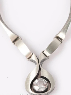 Silver halsband med bergkristall  - Unikt halsband i silvermed en modern, böjd design och en rund klar bergkristall i mitten. Kedjan består av breda, platta länkar som ger ett stilrent och elegant intryck. Perfekt för dig som gillar minimalistiska smycken med en twist. Den är från märke Karl Laine och gjord av silver. 