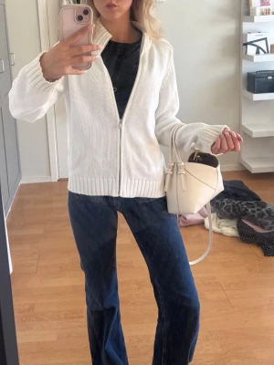 Vit stickad ziptröja - Snygg vit stickad ziptröja med ribbade muddar och krage. Tröjan har en rak passform och dragkedja framtill. Perfekt att slänga över en t-shirt och matcha med jeans för en clean look. Mycket bra skick. Passar som en S. 