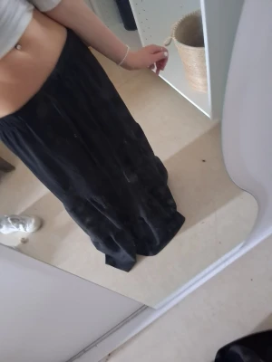 Svart långkjol från 157 - Säljer en svart långkjol från 157 i storlek XS. Kjolen har en enkel och flowy design med resår i midjan för skön passform. Perfekt att styla med crop tops eller stickade tröjor för en chill look.