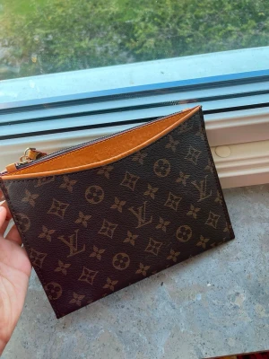 Helt ny   - Snygg plånbok  i klassiskt monogrammönster. Mörkbrunt konstläder med ljusbruna detaljer och guldfärgad dragkedja. Perfekt storlek för kort, kontanter och småsaker. Ikonisk design som aldrig går ur tiden.