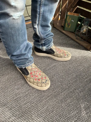 Gucci slip-on sneakers med ormprint - Säljer ett par snygga slip-on sneakers från Gucci med klassiskt GG-mönster. Bra skick (se defekter sista bilder), en dustbag och gucci kort medföljer!✅ Skriv vid funderingar och följ för mer!🤝 