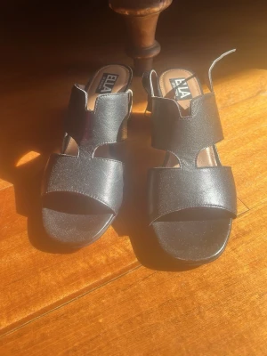 Svarta chunky sandaler med klack - Sandal klackar med öppna tår och justerbar spänne för att sätta åt så tajt man vill den sitter vid ankeln.