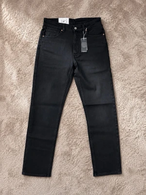Vailent Jeans svarta  - Snygga svarta jeans med rak passform och hög midja. Klassisk femficksmodell med bälteshällor och knappgylf. Jeansen är tillverkade i ett mjukt denimtyg som ger en clean look. Perfekta till alla typer av outfits.