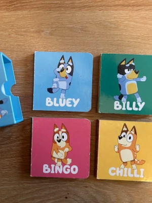 Bluey pekboksset med fyra böcker - Ett färgglatt pekboksset med fyra små böcker om Bluey, Billy, Bingo och Chilli. Böckerna har hårda pärmar och sidor, perfekta för yngre läsare. Varje bok har illustrationer och enkla texter på svenska med karaktärer från Bluey-universumet. Använt fint skick, lätt skav kav förekomma.