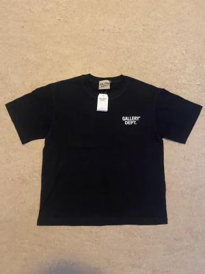 Svart Gallery Dept Tee storlek M - Svart klassisk Gallery Dept T-Shirt i storlek M True To Size, det är en liten logga på vänster bröst oxh en större logga på baksidan. Perfekt om du vill ha en skön, lite diskret men cäldigt snygg tröja. Perfekt för folk som gillar streetwear/hiphop stilen.
