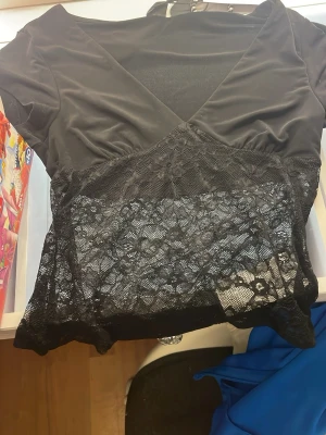 Svart spets tröja - Säljer en svart urringad spets tröja från Gina tricot som är alldeles ny och lappen är fortfarande kvar🫰🏼(pris kan diskuteras)🫰🏼