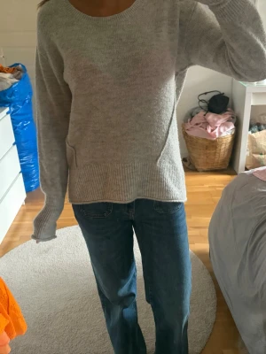 Ljusgrå stickad tröja L.O.G.G. - Mysig ljusgrå stickad tröja från L.O.G.G. med rund halsringning och ribbade muddar vid ärmslut och nederkant. Tröjan har en avslappnad passform och är perfekt för lager på lager. Tillverkad i mjukt material som känns skönt mot huden. OPS den har små fläckar som förmodligen går bort med vanish i tvätt men annars i bra skick