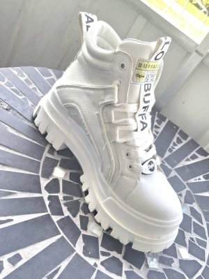  Buffalo aspha NC MID BS ✨️ - Chunky Buffalo sneakers i helvitt med högt skaft och grov platåsula. Skorna har tydliga logodetaljer på plös och häl, samt robust snörning. Endast använda 3 gånger. Säljes pga fel storlek