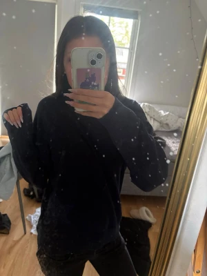 Marinblå stickad tröja med stjärndetalj - Mysig svart stickad tröja med glittriga stjärnor. Tröjan har en avslappnad passform, långa ärmar och ribbstickade muddar vid ärmslut och hals. Perfekt för dig som gillar enkla men snygga detaljer.