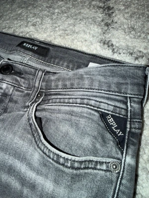 Replay jeans  - Säljer ett par gråa jeans från Replay då de är för små för mig. Jeansen har snygga slitningar och detaljerade sömmar. Perfekta för dig som gillar en avslappnad men ändå stilren look. Hör av dig om du har några frågor.