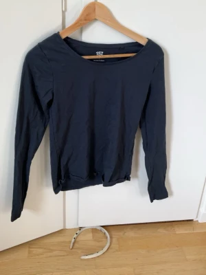Mörkblå långärmad topp från 157 - En enkel och stilren mörkblå långärmad topp från 157. Tillverkad i mjuk bomull med lite stretch för skön passform. Perfekt till jeans eller kjol och har en klassisk rund halsringning.