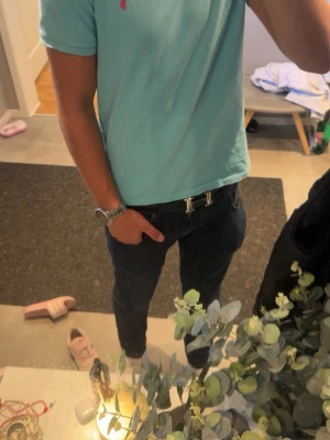 Ljusblå kortärmad piké från Polo Ralph Lauren - Snygg ljusblå pikétröja från Polo Ralph Lauren med klassisk krage och två knappar vid halsen. Ikoniska rosa loggan. Tröjan är i storlek M. Fint skick