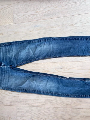 Blå slim fit jeans med tvättade detaljer - Säljer ett par blå slim fit jeans replay storlek w28