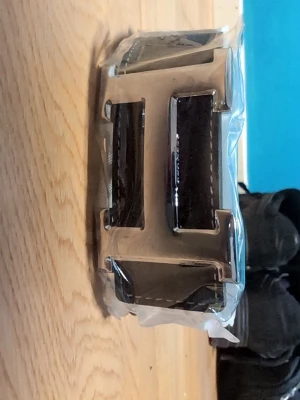 Svart bälte med stor silverspänne - Snyggt svart bälte med ett stort, iögonfallande silverspänne i metall. Bältet har en klassisk design och är tillverkat i skinn med tydliga sömmar längs kanterna. Perfekt accessoar för att lyfta din outfit.
