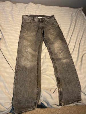 Grå raka jeans med tvättad look - Säljer ett par grå jeans med rak passform och tvättad look. 