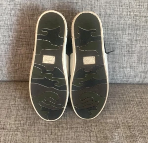 Blå och vita sneakers i mocka - Snygga sneakers i blå mocka med vita detaljer och vit sula. Skorna har mörkblå snören och en klassisk låg profil. Perfekta för dig som gillar stilrena och sportiga skor med en modern touch.