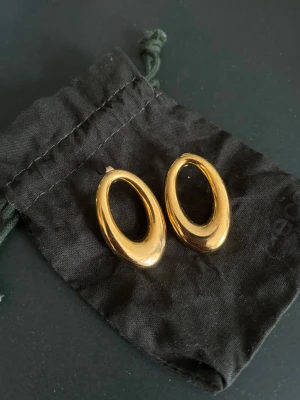 Guldiga örhängen - Snygga ovala örhängen! Cirka 4cm på längden. Använda endast en gång. 