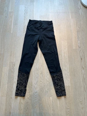 Svarta leggings med reflex ben - Snygga svarta leggings med hög midja och unika mönstrade detaljer i reflex på nedre delen av benen. Stretchigt material som sitter skönt och följer kroppen. Lätt fodrade vilket gör det perfekt för vinteraktiviteter ute (i mörker). Tveka inte på att skriva en fråga eller be om fler bilder.🌸🌸