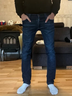 Nudie Jeans Grim Tim - Säljer dessa sjukt snygga jeansen från Nudie i den populära modellen Grim Tim. Färgen heter Navy Thunder. De är i superbra skick och i storlek 32/34 men lite små i storleken. Personen på bilden är 180 cm och väger 67 kg. 