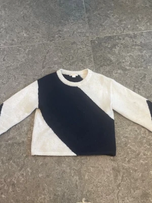 Stickad tröja! - Säljer en stickad tröja med breda diagonala block i marinblått och vitt. Tröjan har rund halsringning.