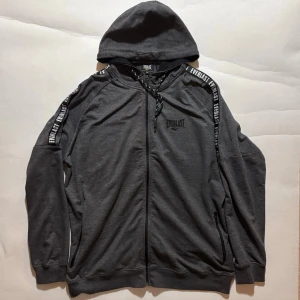 Everlast Hoodie - Everlast hoodie, grå med svarta detaljer  Skick enligt bilder. Rätt så tunnt material.  Skicka ett meddelande om du har frågor eller vill se fler bilder