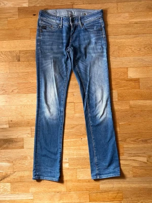 G-star midge straight wmn  28/32 - Snygga ljusblå  jeans med tvättade detaljer på låren och knäna. Klassisk femficksmodell med dragkedja och knapp i midjan. Jeansen har raka ben. Sparsamt använda då storleken inte varit helt bra. 