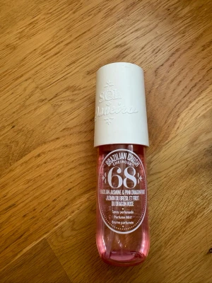 Sol de Janeiro Brazilian Crush 68 - Parfymmist med doft av brasiliansk jasmin och pink dragonfruit från Sol de Janeiro. Flaskan är cylinderformad i rosa plast med vit kork och tydlig logga. Perfekt för dig som gillar fräscha och exotiska dofter.