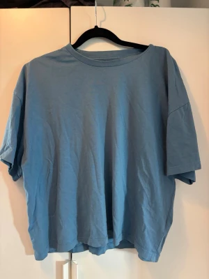 Blå oversized t-shirt från BikBok - En enkel blå t-shirt från BikBok. T-shirten har rund halsringning och korta ärmar. Tillverkad i mjuk bomull som känns skön mot huden. 