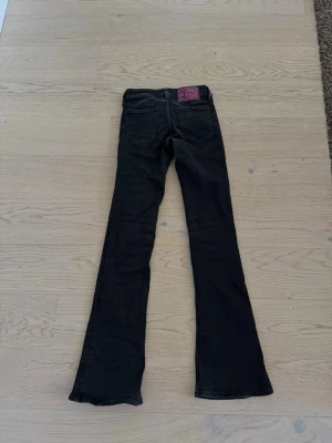Svarta weekday  bootcut jeans  - Säljer ett par svarta bootcut jeans med klassisk femficksdesign och utsvängda ben. dom är storlek 27/34! bara använda ett få tal gånger, passar jättebra nu till hösten! pris kan diskuteras🤍