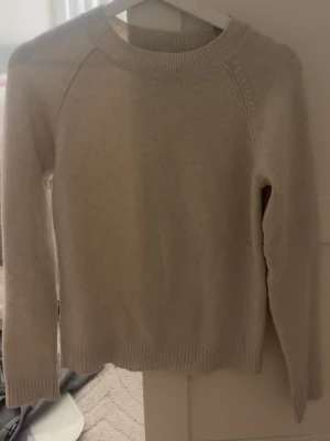 Beige stickad tröja - En enkel och stilren beige stickad tröja ifrån Vero Moda. Har en liten defekt på magen.