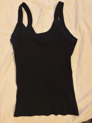 Svart ribbat linne - Fint linne från Gina tricot med lite tjockare band! Linnet är ribbat.