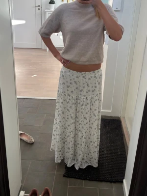 Vit långkjol med blommigt mönster - Jättefin kjol från Stradivarius!! Skicket syns på bilderna. Om du har några frågor eller vill ha mer info är det bara att fråga💞