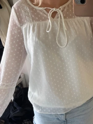 Vit prickig blus med spetsdetaljer - Säljer denna söta blus med spetsdetaljer. Stl 34/xs. Använd fåtal gånger